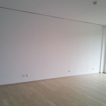 Weiß gestrichener Raum mit Boden aus hellem Holz